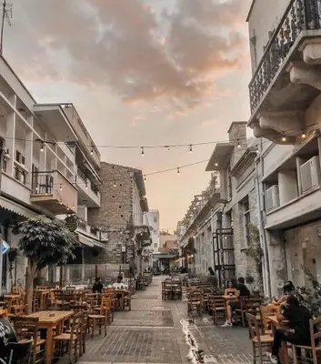 an empty street with tables and chairs and buildings at Charming House in the Heart of Limassol in Limassol