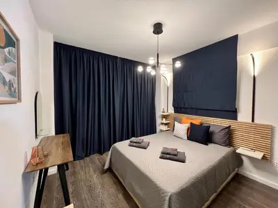 a bedroom with a large bed and a blue wall at Fat Cow Apartments in Larnaka