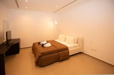 a bedroom with a bed and a flat screen tv at Seafront Villa Layla by Ruidoso Luxury in Ayia Napa