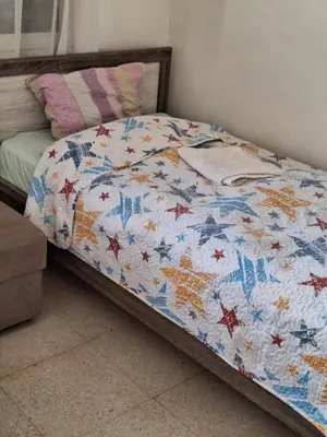 a bed with a quilt with stars on it at 2 bedroom apartment in Makenzi in Larnaka