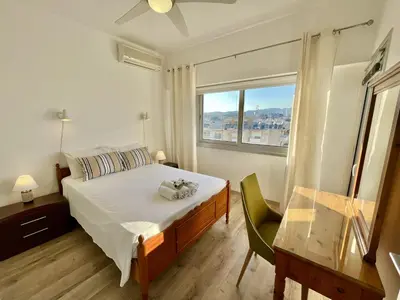 a bedroom with a large bed and a window at Seaview Beach Apartment Dasoudi in Limassol