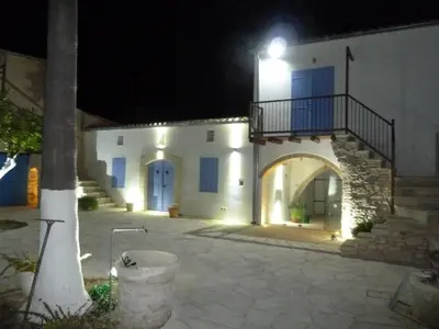 a large white building with a balcony at night at To Archontiko tis Anastasias in Athienou