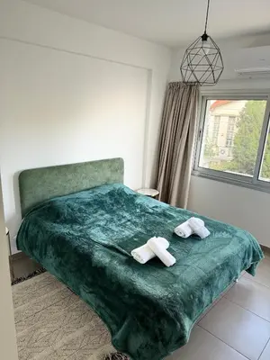 a bedroom with a green bed with two towels at Anastasia 1 Bedroom Apartment in Limassol