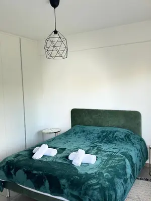 a bedroom with a green bed with two towels at Anastasia 1 Bedroom Apartment in Limassol