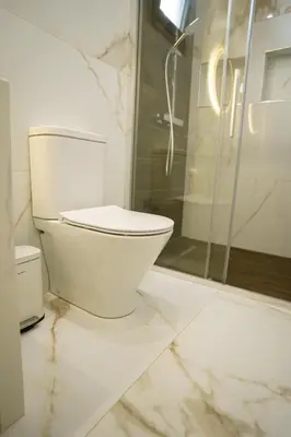 a white bathroom with a toilet and a shower at Oasis By The Sea - Cyprus in Larnaka