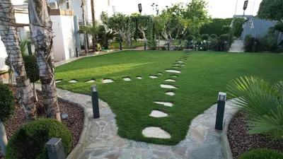 a garden with a path in the grass at Oasis By The Sea - Cyprus in Larnaka