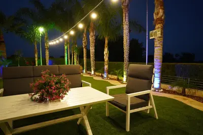a patio with two chairs and a table and lights at Oasis By The Sea - Cyprus in Larnaka