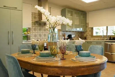 a dining room table with a vase of flowers on it at Oasis By The Sea - Cyprus in Larnaka