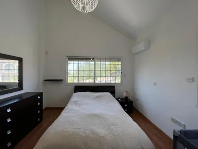 a bedroom with a large bed and two windows at Villa Sawa by Ezoria Villas in Limassol