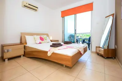 a bedroom with a bed and a large window at Sea View APT*Spacious balcony*200m to the Beach in Paralimni