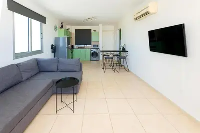 a living room with a couch and a kitchen at Sea View APT*Spacious balcony*200m to the Beach in Paralimni
