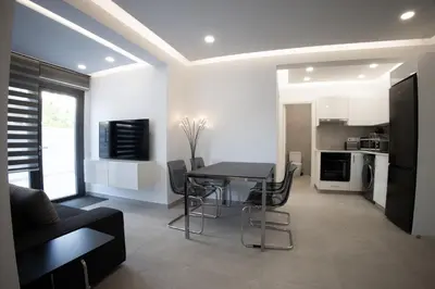 a kitchen and dining room with a table and chairs at Phaedrus Living: Luxury Mackenzie Flat in Larnaka