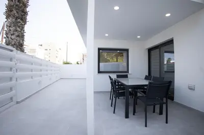 a kitchen and dining room with a table and chairs at Phaedrus Living: Luxury Mackenzie Flat in Larnaka