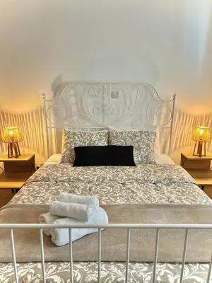 a bedroom with a large white bed with two lamps at Stou Stefani in Agros