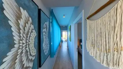 a hallway with blue walls and art on the walls at Billy's Place Protaras Luxury Villa with private pool with heated pool option for autumn and winter months in Paralimni