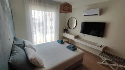 a bedroom with a bed and a tv and a window at My Mythical Pearl in Protaras
