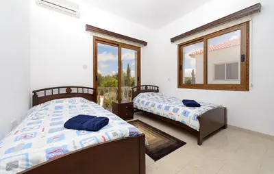 two beds in a room with a window at Villa Sam in Ayia Napa