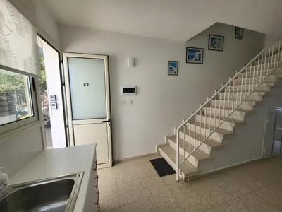 a hallway with a staircase and a stair case at Mattis Seafront Beachhouse in Pervolia