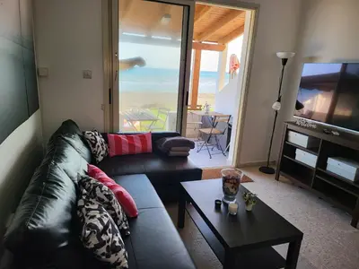 a living room with a couch and a tv and a table at Mattis Seafront Beachhouse in Pervolia