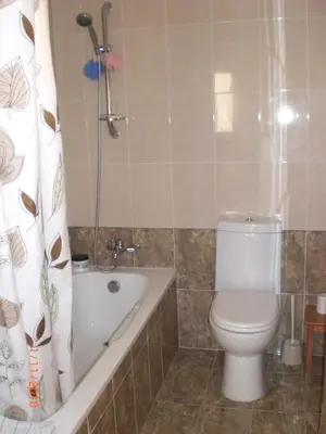 a bathroom with a toilet and a tub and a shower at St. Lazaros Seaside Apartment in Larnaka