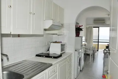 a white kitchen with a sink and a microwave at Stadem Studios in Larnaka