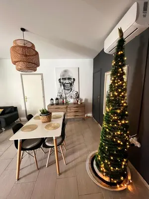 a christmas tree in a living room with a table and chairs at Green Door Apartment in Limassol