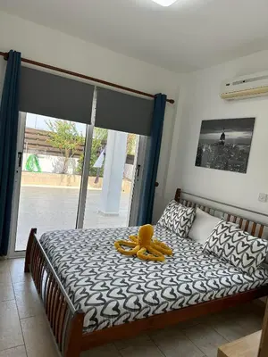 a teddy bear sitting on a bed in a bedroom at Sidra's Apartment in Paralimni