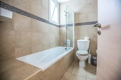a bathroom with a bath tub and a toilet at Villa Cayenne in Protaras