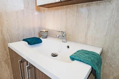 a bathroom sink with two green towels on it at Cyprus Dreams Village in Protaras