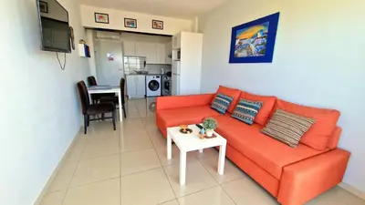 a living room with a orange couch and a table at Cyprus Dreams Village in Protaras