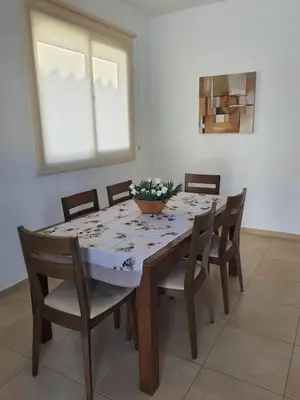a dining room table with chairs and a bowl of flowers on it at Yama's Villa - Polyxenia luxury, protaras, cyprus in Protaras