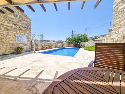 a swimming pool in a yard with a wooden bench at Skarinou Village Poolside Escape Studio with Pool facilities in Skarinou