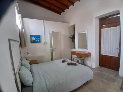 a bedroom with a bed and a desk and a window at Skarinou Village Poolside Escape Studio with Pool facilities in Skarinou