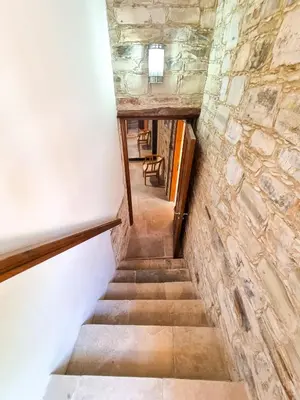 a staircase in a building with a stone wall at Skarinou's Landhouse Poolside Heaven Apartment in Skarinou