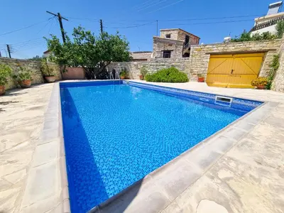 a swimming pool in the backyard of a house at Traditional Village Pool Paradise Family Apartment in Skarinou