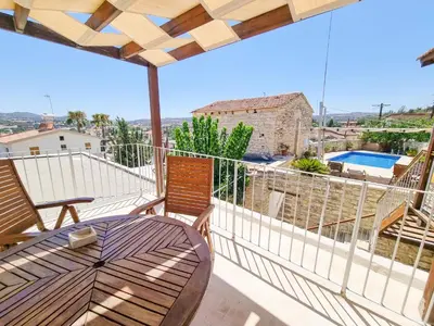 a patio with a table and chairs on a balcony at Village Charm with Pool Apartment at Skarinou in Skarinou