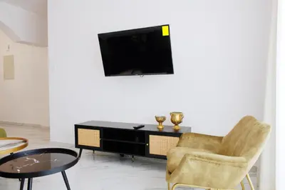 a living room with a tv and a chair and a table at Musan Boutique Apartments in Ayia Napa