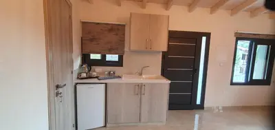 a kitchen with a sink and a counter and a door at Village Gem Peledri Studio in Pelendri