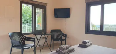 a room with a bed and two chairs and a table at Village Gem Peledri Studio in Pelendri