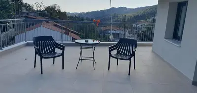 three chairs and a table on a balcony with a view at Village Gem Peledri Studio in Pelendri
