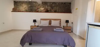 a bedroom with a large bed with purple blankets at Chic Elegance Meets Village Gem in Pelendri