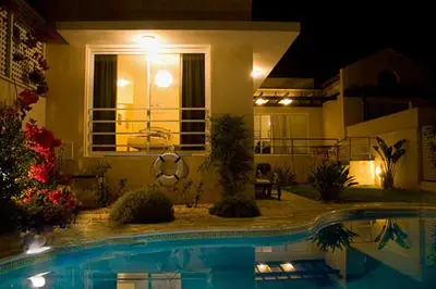a swimming pool in front of a house at night at Anastasia in Pissouri