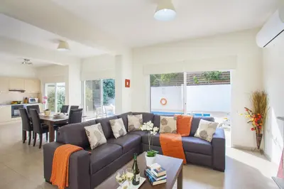 a living room with a couch and a table at Villa Cliantha in Protaras