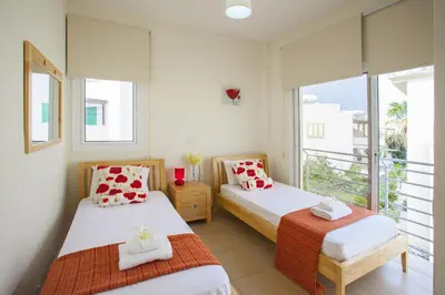 a bedroom with two beds and a balcony at Villa Cliantha in Protaras