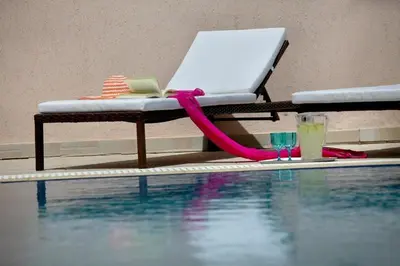 a table with a laptop on it next to a swimming pool at Michelle 8 in Protaras