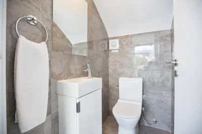 a bathroom with a toilet and a sink and a mirror at Villa Prol24,brand New 2bdr Protaras Villa with Pool,close to Fig Tree Bay Beach in Protaras