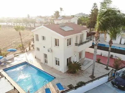 a large white house with a swimming pool at Sunset Pearl Holiday Villa in Ayia Napa
