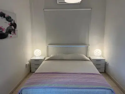 a bedroom with a bed with two nightstands at Themis Beach Apartments in Larnaka