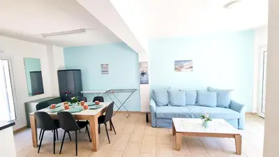 a living room with a blue couch and a table at Dream Escape Apt 1 - 6 min walk to Kastella Beach! in Larnaka