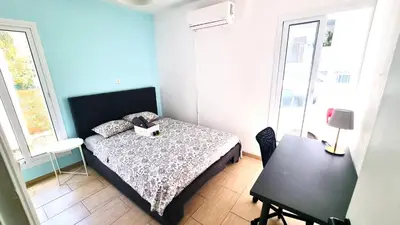 a small bedroom with a bed and a table at Dream Escape Apt 1 - 6 min walk to Kastella Beach! in Larnaka